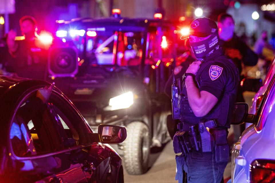 Miami Beach Police arrive on the scene to disperse a crowd that formed near Seventh Street and Alton Road, after crowds were sent away from Ocean Drive in Miami Beach, Fla., on Sunday, March 21, 2021. An 8 p.m. curfew has been extended in Miami Beach after law enforcement worked to contain unruly crowds of spring break tourists. (Daniel A. Varela/Miami Herald via AP)