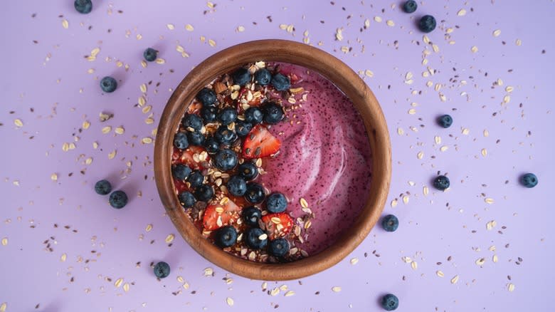 Açaí bowl with berries and purple background