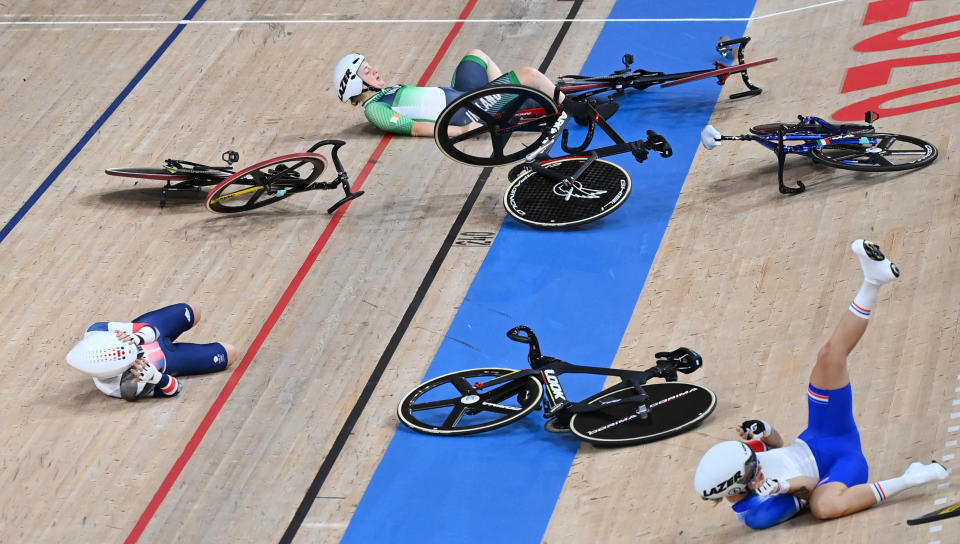 (From L) Britain's Laura Kenny, Ireland's Emily Kay and France's Clara Copponi lie on the track after crashing during the women's track cycling omnium scratch race during the Tokyo 2020 Olympic Games at Izu Velodrome in Izu, Japan, on August 8, 2021. (Photo by Greg Baker / AFP) (Photo by GREG BAKER/AFP via Getty Images)