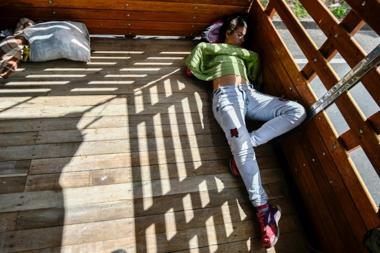 Pregnant Venezuelan Mariangela Ascano sleeps in the back of a pick-up truck on her journey south to Ecuador