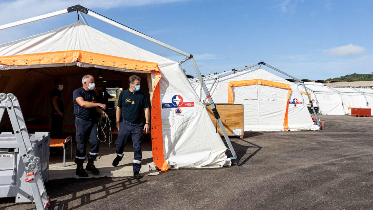 Members of the ESCRIM unit (Civil security rapid medical intervention element) finalize the installation of a field hospital for the medical staff on the tarmac of the old heliport of the Cayenne hospital center, on June 25, 2020 to prevent the spread of the COVID-19 (novel coronavirus) pandemic. (Photo by jody amiet / AFP)