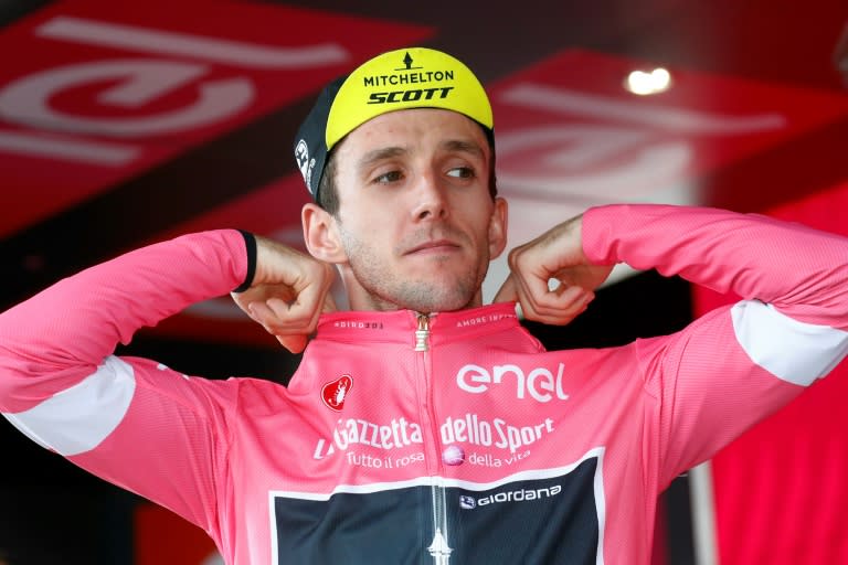 Simon Yates puts on the pink jersey after surviving attacks on the 18th stage