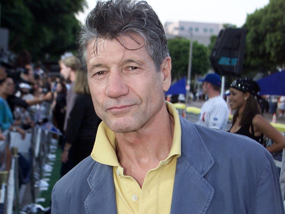 Fred Ward in a blue jacket and yellow shirt