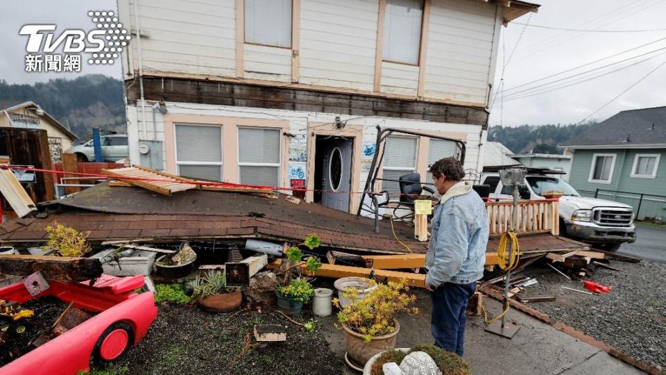 原本在二樓的陽台整個被震垮，屋主無奈的站在屋前查看災損。（圖／達志影像路透社）