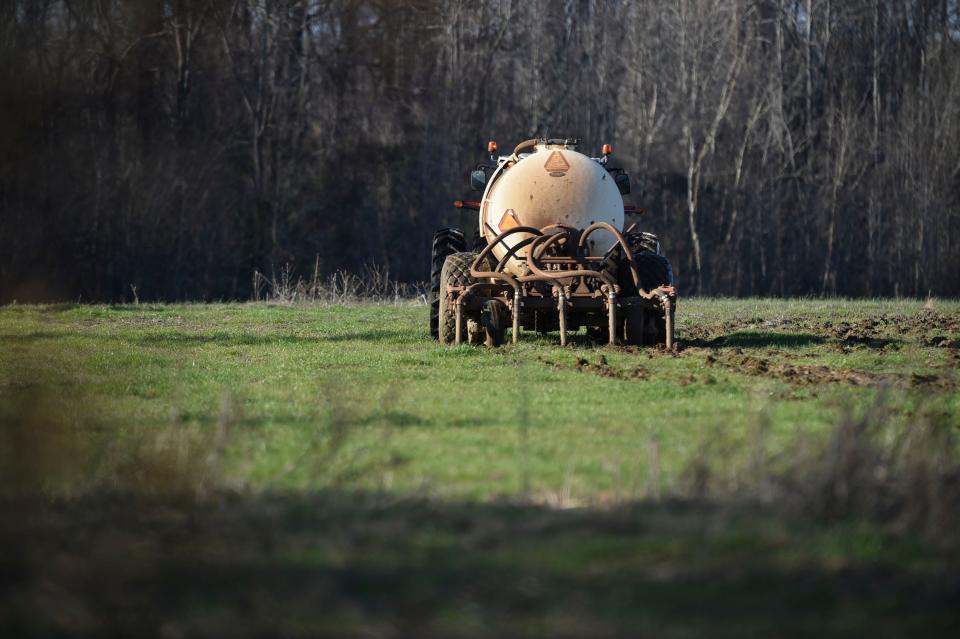 A tractor pulling a tank full of soil amendment sprays the ground at a farm near Warren County, Ga., on Jan. 26, 2023.