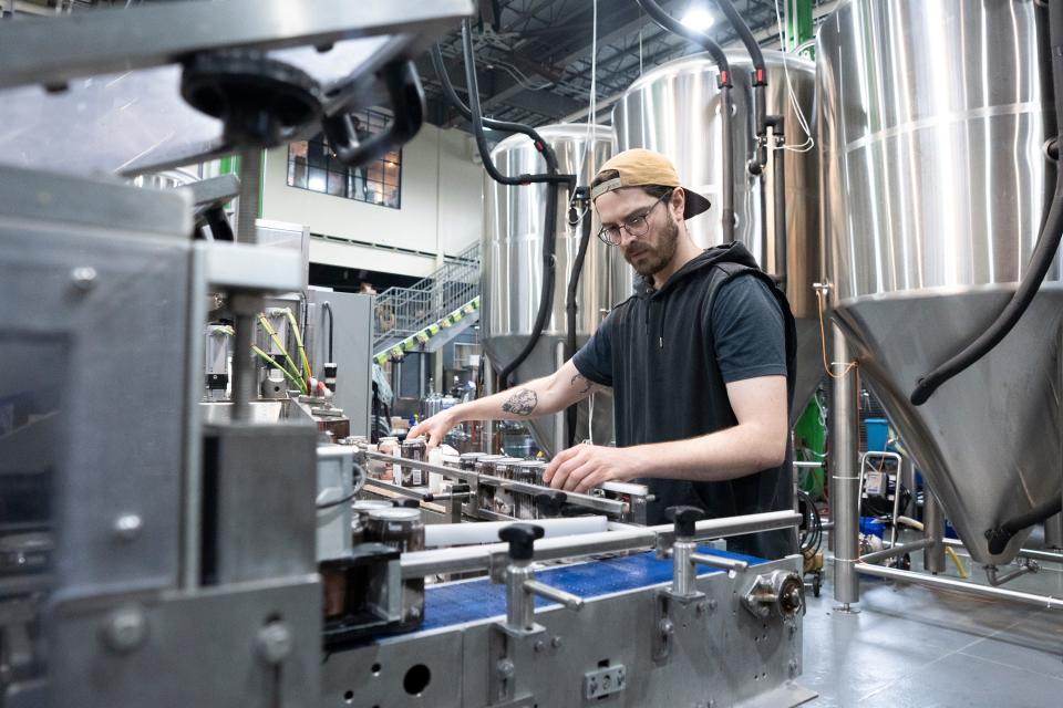 Head Brewer Chris Carter sorts cans for six-packs of "Beer Me" in the canning area of Seventh Son Brewing Co.