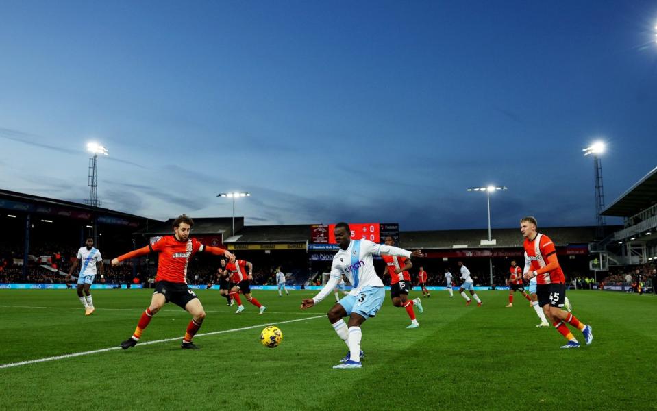 A general view as Tyrick Mitchell of Crystal Palace crosses the ball whilst under pressure from Tom Lockyer of Luton Town during the Premier League match between Luton Town and Crystal Palace at Kenilworth Road on November 25, 2023 in Luton, England.