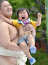 A crying baby is carried by a student sumo wrestler during the "Baby-cry Sumo" competition at Tokyo's Sensoji temple on April 30, 2011. Some 50 babies aged under one participated in the annual baby crying contest. Japanese parents believe that sumo wrestlers can help make babies cry out a wish to grow up with good health. AFP PHOTO/Yoshikazu TSUNO