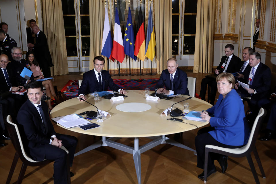 French President Emmanuel Macron, center left, Russian President Vladimir Putin, center right, German Chancellor Angela Merkel and Ukrainian President Volodymyr Zelenskiy, left, attend a working session at the Elysee Palace Monday, Dec. 9, 2019 in Paris. Russian President Vladimir Putin and Ukraine's president are meeting for the first time at a summit in Paris to find a way to end the five years of fighting in eastern Ukraine. (AP Photo/Thibault Camus, Pool)