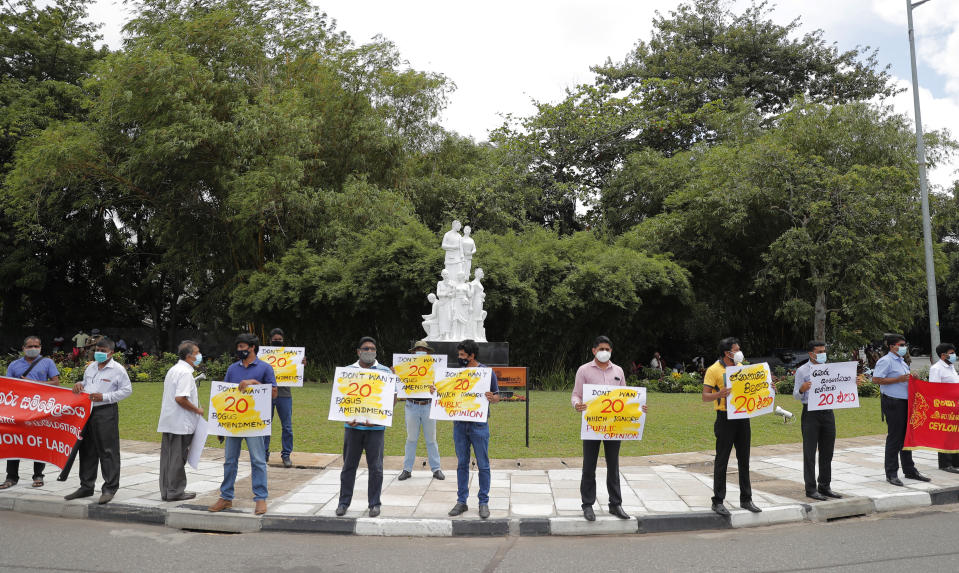 Sri Lankan trade union and civil society activists hold placards outside the parliament as they protest against a proposed constitution amendment that would consolidate power in the president’s hands in Colombo, Sri Lanka, Wednesday, Oct. 21, 2020. (AP Photo/Eranga Jayawardena)