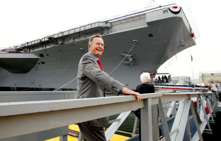 FILE PHOTO: Former President George H.W. Bush walks the gangway as he arrives for the christening ceremony of the USS George H.W. Bush at Northrop-Grumman's shipyard in Newport News, Virginia October 7, 2006. REUTERS/Kevin Lamarque/File Photo