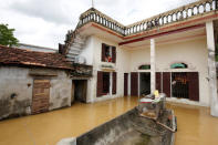 Poeple sit on a window of their flooded house after a heavy rainfall caused by Son Tinh storm in Ninh Binh province, Vietnam. REUTERS/Kham