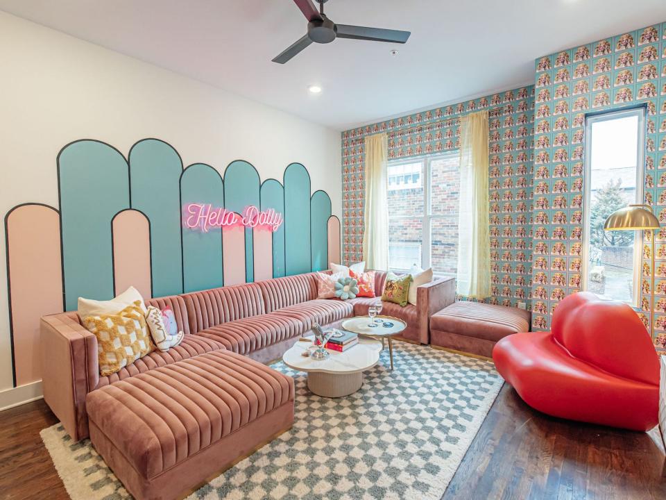 A living room with mural that says "Hello Dolly."