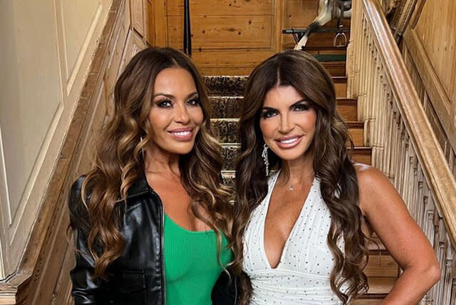 Dolores and Teresa smiling together in front of stairs.