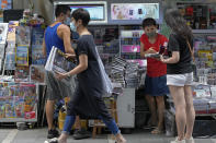 People buy Apple Daily at a downtown street in Hong Kong Friday, June 18, 2021. The pro-democracy paper increased its print run to 500,000 copies on Friday, a day after police arrested five top editors and executives and froze $2.3 million in assets linked to the media company. (AP Photo/Vincent Yu)