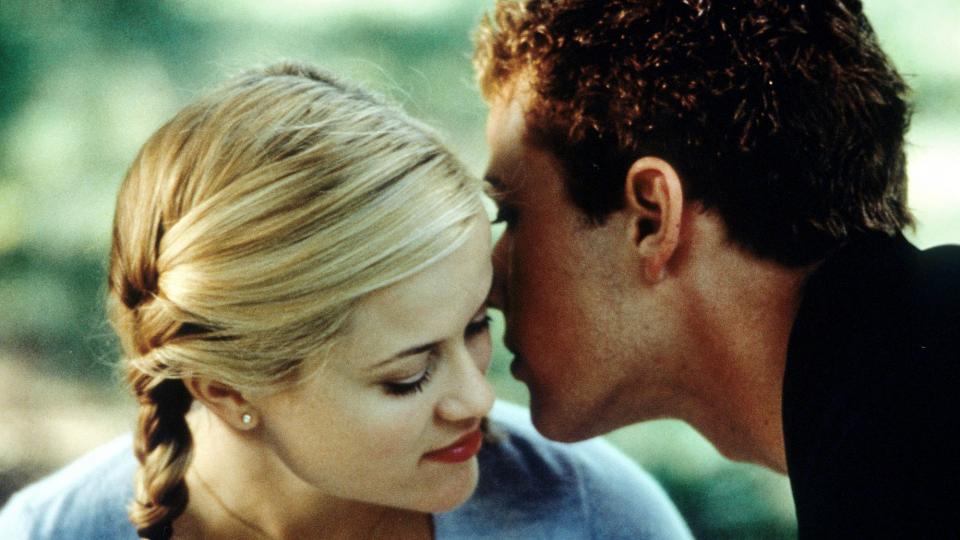 Reese Witherspoon listens as Ryan Phillippe whispers in her ear in a scene from the film 'Cruel Intentions', 1999