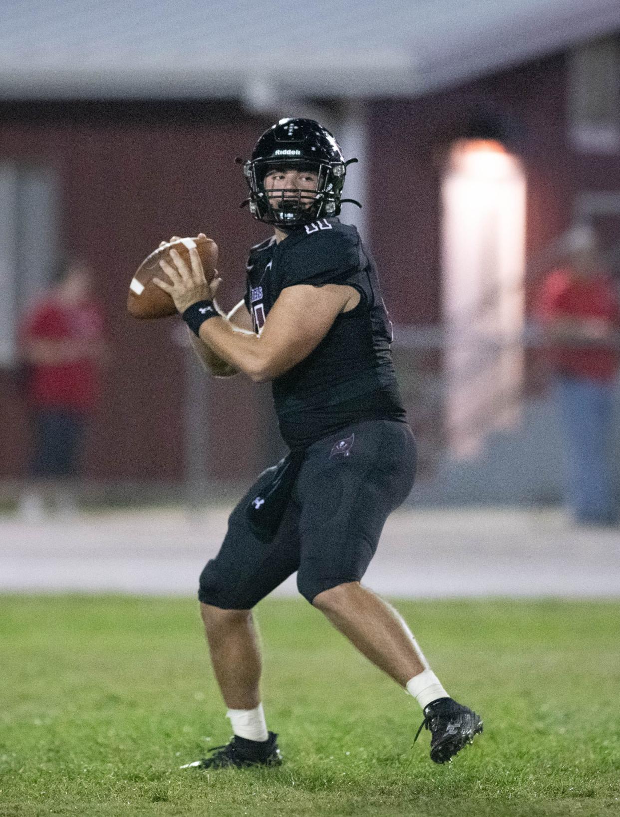 Quarterback Hunter Pfiester (11) gets set to pass during the Tate vs Navarre football game at Navarre High School on Friday, Sept. 15, 2023.