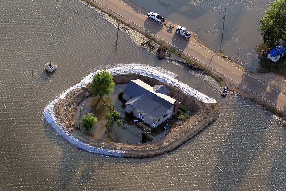 VICKSBURG, MS - MAY 18: A levee protects a home surrounded by floodwater from the Yazoo River May 18, 2011 near Vicksburg, Mississippi. The flooded Mississippi River is forcing the Yazoo River to top its banks where the two meet near Vicksburg causing towns and farms upstream on the Yazoo to flood. The Mississippi River at Vicksburg is expected to crest May 19. Heavy rains have left the ground saturated, rivers swollen, and have caused widespread flooding along the Mississippi River from Illinois to Louisiana. (Photo by Scott Olson/Getty Images)