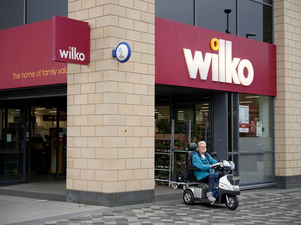 A woman in a mobility scooter leaves the Wythenshawe branch of Wilco in Manchester in August (Getty Images)