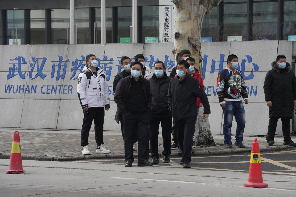 Plainclothes security personnel stand outside the Wuhan Center for Disease Control and Prevention before the World Health Organization team arrive to make a field visit in Wuhan in central China's Hubei province on Monday, Feb. 1, 2021. (AP Photo/Ng Han Guan)