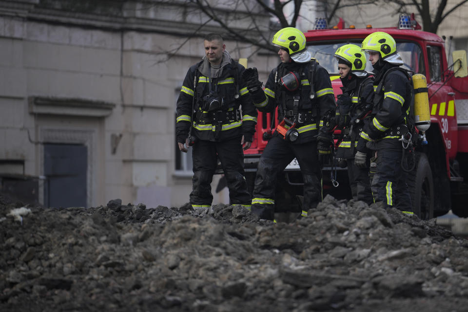 Firefighters survey the site after a Russian attack in Kyiv, Ukraine, Thursday, March 21, 2024. Around 30 cruise and ballistic missiles were shot down over Kyiv on Thursday morning, said Serhii Popko, the head of Kyiv City Administration. The missiles were entering Kyiv simultaneously from various directions in a first missile attack on the capital in 44 days. (AP Photo/Vadim Ghirda)