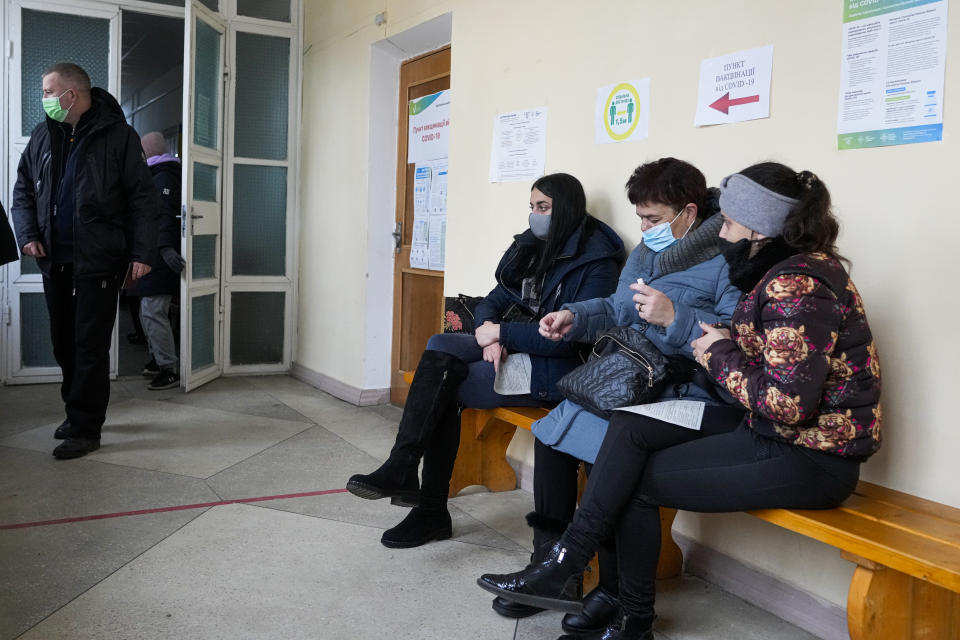 People wait for their turn to have an anti-coronavirus vaccine in a vaccination center in Morshyn, Ukraine, Tuesday, Nov. 16, 2021. In Morshyn, a scenic town nestled at the Carparthian foothills in the Lviv region, 74% of 3,439 residents have been fully vaccinated. A small spa town in western Ukraine stands out in a country where just under a quarter of the population has received coronavirus vaccines. (AP Photo/Efrem Lukatsky)