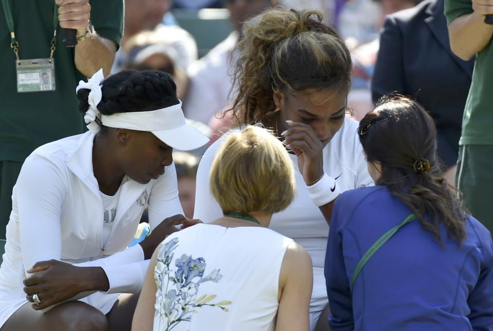 Serena Williams of the U.S. appears unwell before retiring from her women's doubles tennis match with Venus Williams of the U.S. against Kristina Barrois of Germany and Stefanie Voegele of Switzerland at the Wimbledon Tennis Championships, in London