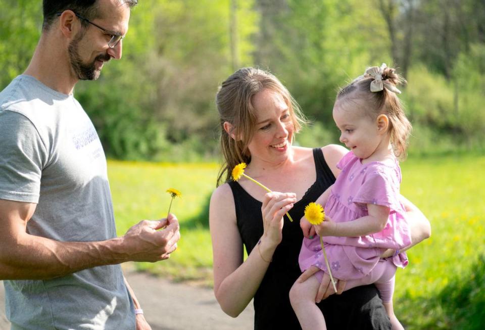 Freya Barragan laughs with her parents Adrain and Carly as they pick dandelions and flowers on Tuesday, April 30, 2024. The family is hoping to get a service dog for Freya to help with her seizures caused by Dravet syndrome. Abby Drey/adrey@centredaily.com