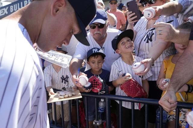 New York Yankees' Aaron Judge signs autographs for fans before a spring training baseball game against the Washington Nationals Wednesday, March 1, 2023, in Tampa, Fla. (AP Photo/David J. Phillip)