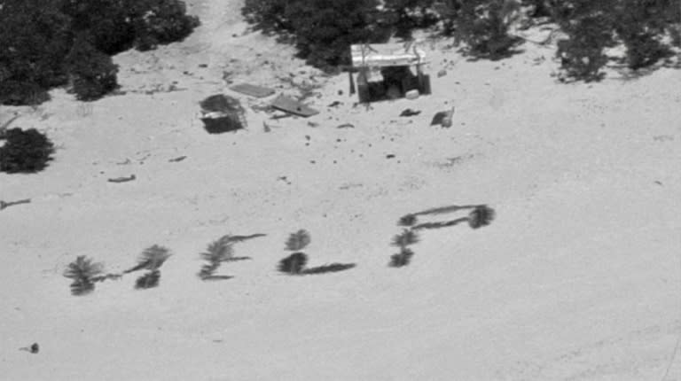 Vue aérienne du signe "HELP" tracé dans le sable par des marins, sur la petite île Pikelot dans le Pacifique, transmise par les gardes-côtes américains le 11 avril 2024 (-)