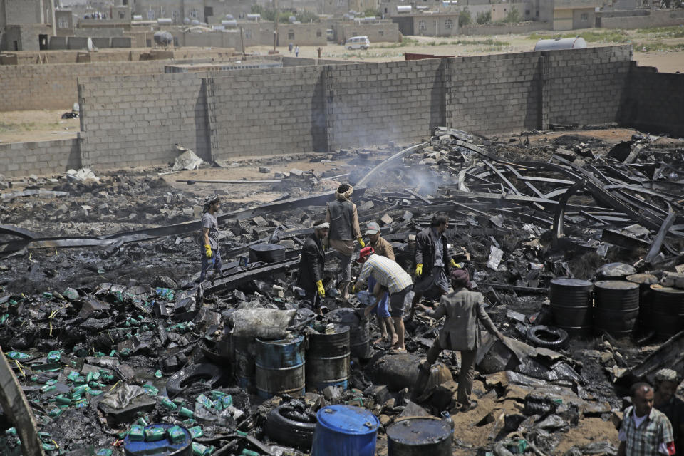 Workers salvage oil canisters from the wreckage of a vehicle oil store hit by Saudi-led airstrikes in Sanaa, Yemen, Thursday, July 2, 2020. (AP Photo/Hani Mohammed)