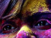 An Indian girl with her face covered with colored powder looks on as she celebrates Holi, the spring festival of colors, in Calcutta, India, Saturday, March 22, 2008. (AP Photo/Sucheta Das)