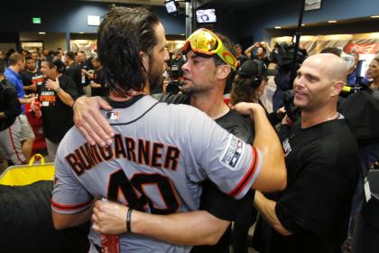 Giants pitcher Madison Bumgarner, left, hugs Ryan Vogelsong as they celebrate the team making the NLCS. (AP)