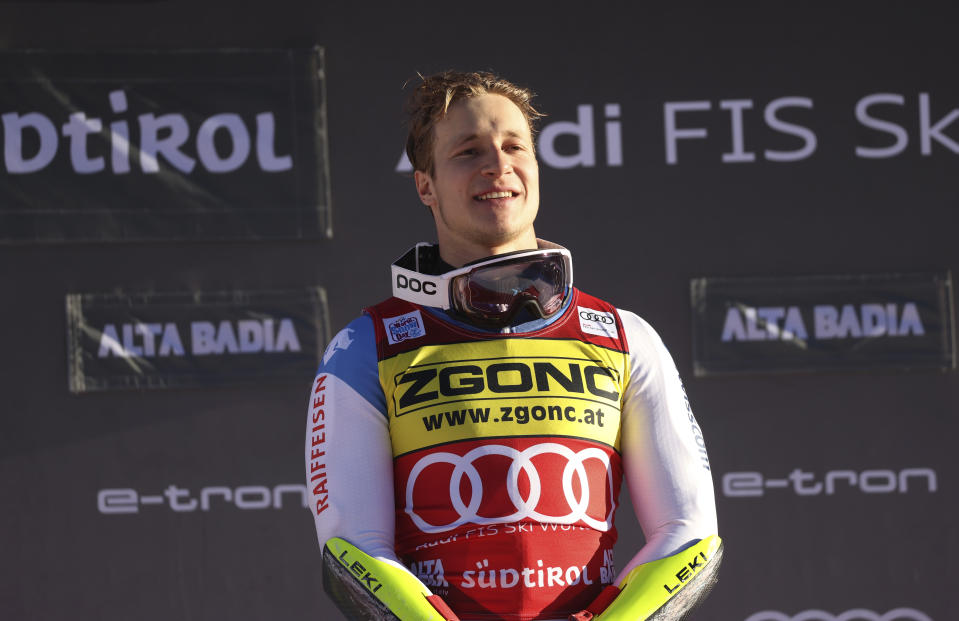 FILE - Switzerland's Marco Odermatt smiles on the podium after winning an alpine ski, men's World Cup giant slalom race in Alta Badia, Italy, on Dec. 20, 2021. Looking for the Next Big Thing in Alpine skiing? Look no further than Marco Odermatt. The 24-year-old from Switzerland is a potential superstar who won five gold medals at the junior world championships in 2018 and is currently leading the overall World Cup standings. He’s a legitimate medal threat in three events at the upcoming Beijing Olympics with strong results in giant slalom, super-G and downhill this season. (AP Photo/Alessandro Trovati, File)
