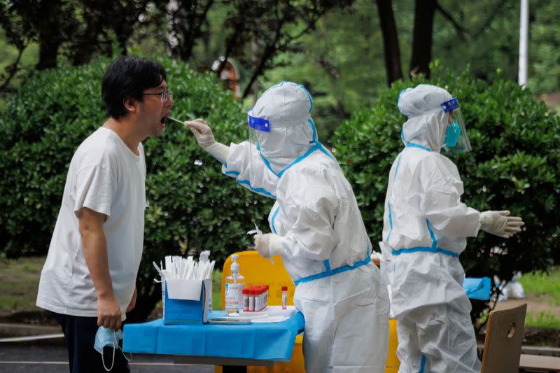 A medical worker takes a swab sample at a nucleic acid testing station, following a coronavirus disease (COVID-19) outbreak, in Beijing