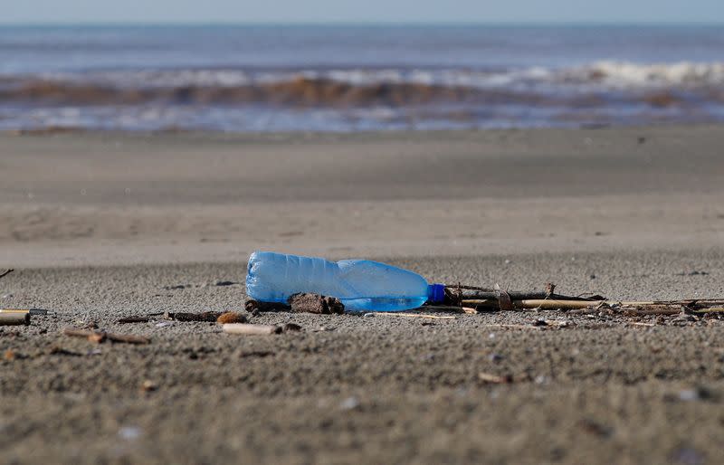 FILE PHOTO: A plastic bottle lies on the sand at Maccarese beach in Italy