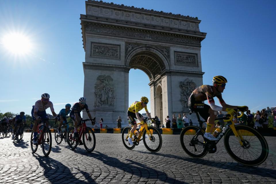 FILE - Denmark's Jonas Vingegaard, wearing the overall leader's yellow jersey, passes Arc de Triomphe during the twenty-first stage of the Tour de France cycling race over 116 kilometers (72 miles) with start in Paris la Defense Arena and finish on the Champs Elysees in Paris, France, Sunday, July 24, 2022. (AP Photo/Thibault Camus, File)