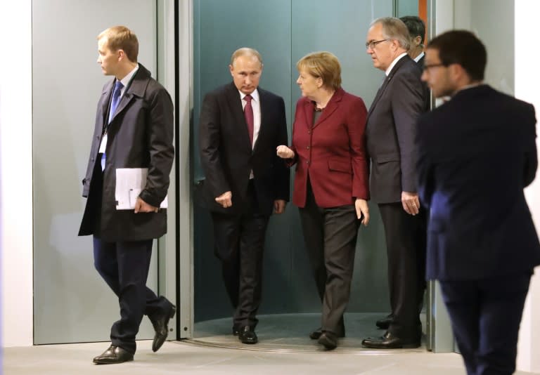 German Chancellor Angela Merkel (3L) talks to Russian President Vladimir Putin at the chancellery in Berlin