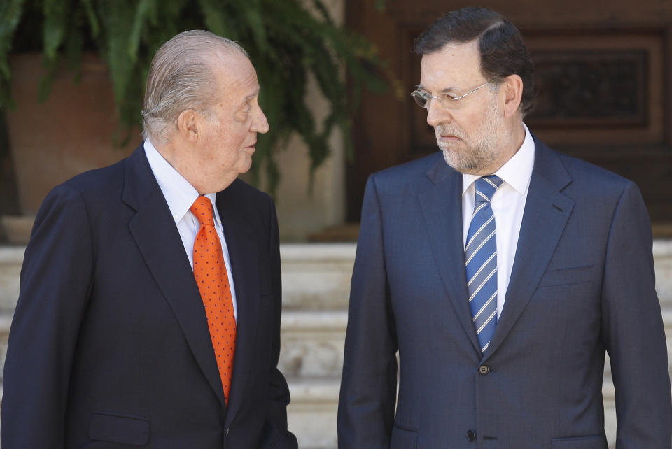 Spain's King Juan Carlos, left, speaks with Spanish Prime Minister Mariano Rajoy before their meeting at the Marivent Palace in Palma de Mallorca, Spain, Tuesday, Aug. 14, 2012. Rajoy said Tuesday he had still not made a decision on asking for more financial aid for his country and would not until the European Central bank made known plans and conditions for for buying troubled government bonds. (AP Photo/Manu Mielniezuk)