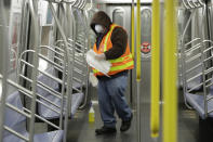 FILE- In this May 5, 2020 file photo a New York Metropolitan Transportation authority worker worker disinfects a subway train at the Coney Island Stillwell Avenue Terminal, in the Brooklyn borough of New York. New York City appears to be on track to begin loosening restrictions in June, but residents who don't yet feel comfortable commuting by subway may have to improvise, NYC Mayor Bill de Blasio said Friday, May 29, 2020. (AP Photo/Frank Franklin II, File)