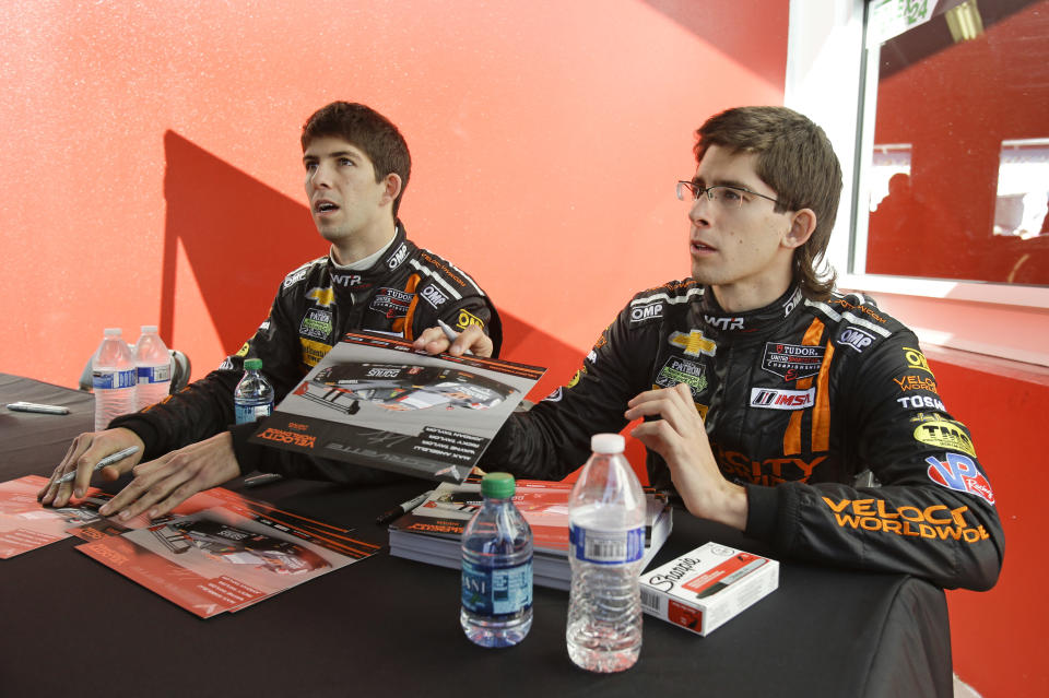 Drivers Ricky Taylor, left, and Jordan Taylor talk with fans during an autograph session prior to the start of the IMSA Series Rolex 24 hour auto race at Daytona International Speedway in Daytona Beach, Fla., Saturday, Jan. 25, 2014.(AP Photo/John Raoux)