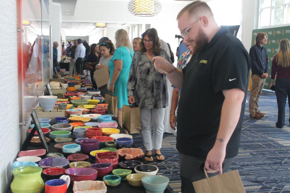 Attendees at the Empty Bowls luncheon fundraiser view handcrafted bowls during the event. The dishes were handcrafted bowls from students from Gainesville High School, Buchholz High School and Oak Hall School.