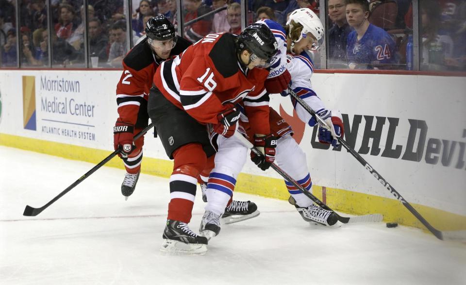 New York Rangers' Carl Hagelin, of Sweden, tries to control the puck as New Jersey Devils' Jacob Josefson (16), of Sweden, and Marek Zidlicky, of the Czech Republic, try to make a steal during the first period of an NHL hockey game game Saturday, March 22, 2014, in Newark, N.J. (AP Photo/Mel Evans)