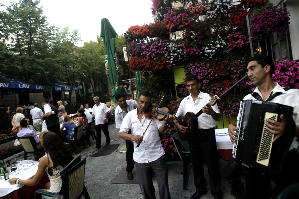 In this photo taken Wednesday, July 10, 2013, a band performs at the Skadarlija bohemian quarter in Belgrade, Serbia. Belgrade today is known for nightlife, clubbing and a fun-loving lifestyle, but its past is scarred by war. Over centuries it was conquered and demolished dozens of times, standing at the historic crossroads between two mighty empires, Turkish to the east and Austro-Hungarian to the west. But Belgrade’s citizens like to compare their city to the mythical phoenix bird that always rises from the ashes. (AP Photo/ Marko Drobnjakovic)