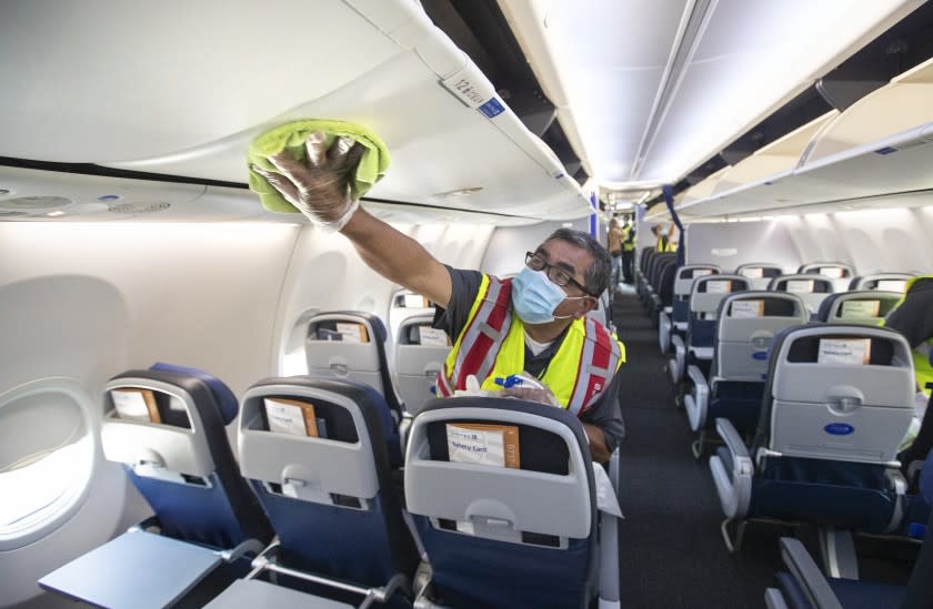 LOS ANGELES, CA -JULY 09, 2020: Cleaning supervisor Jose Mendoza disinfects the cabin area of a United Airlines 737 jet before passengers are allowed to board at LAX on Thursday, July 9, 2020 in Los Angeles, CA. (Mel Melcon / Los Angeles Times)