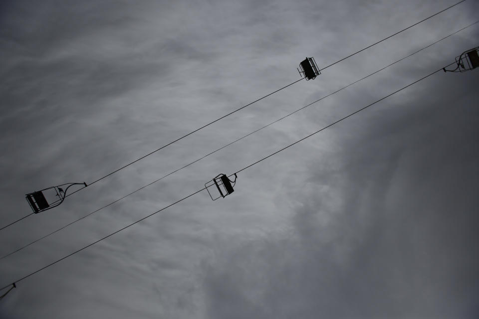 In this picture taken, Friday, Feb. 21, 2014, an empty chairlift is seen near the ski jumping facility at Mt. Igman near the Bosnian capital of Sarajevo. Wartime destruction and negligence have turned most of Sarajevo's 1984 Winter Olympic venues into painful reminders of the city's golden times. The world came together in the former Yugoslavia in 1984 after the West had boycotted the 1980 Olympics in Moscow and Russia boycotted the 1984 Summer Games in Los Angeles. Just eight years later, the bobsleigh and luge track on Mount Trbevic was turned into an artillery position from which Bosnian Serbs pounded the city for almost four years. Today, the abandoned concrete construction looks like a skeleton littered with graffiti. (AP Photo/Amel Emric)