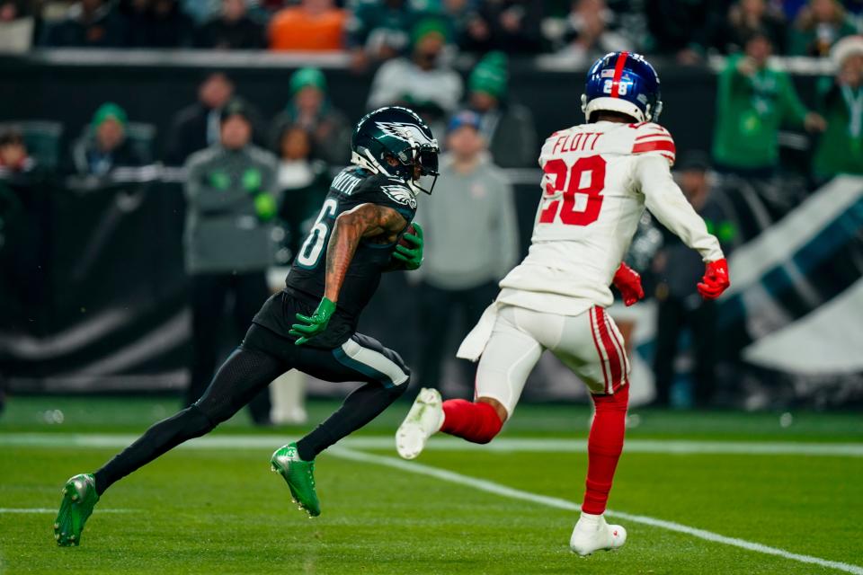 Philadelphia Eagles wide receiver DeVonta Smith scores past New York Giants cornerback Cor'Dale Flott during the first half of an NFL football game Monday, Dec. 25, 2023, in Philadelphia.