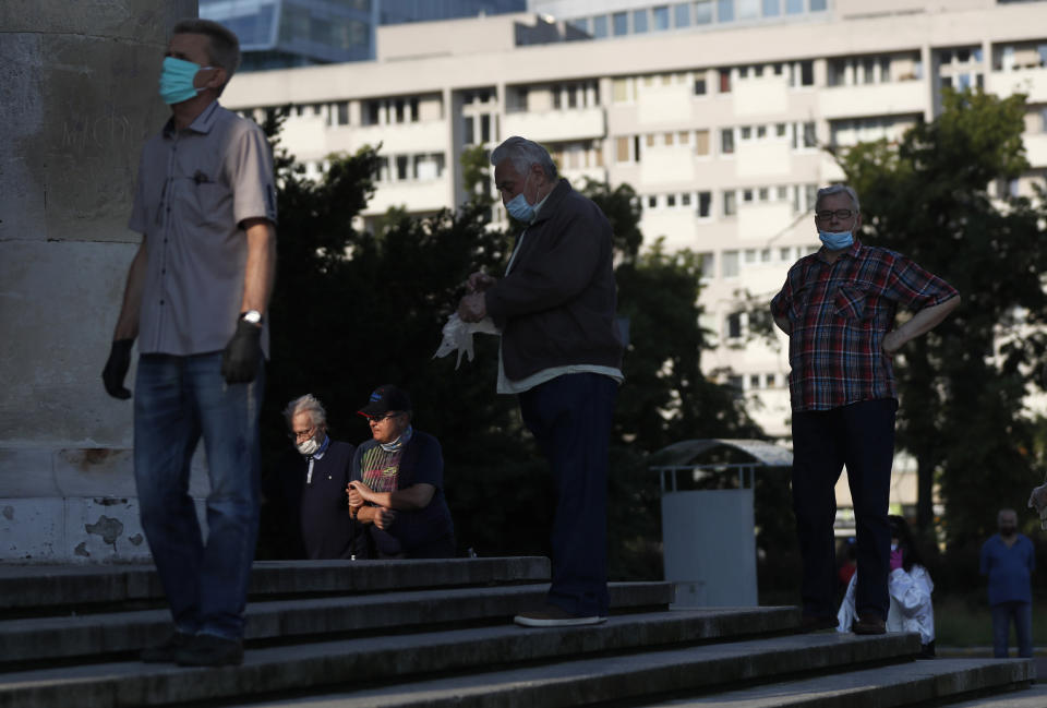 People keep social distancing while waiting in line to cast their vote in presidential election in Warsaw, Poland, Sunday, June 28, 2020. The election will test the popularity of incumbent President Andrzej Duda who is seeking a second term and of the conservative ruling party that backs him. (AP Photo/Petr David Josek)