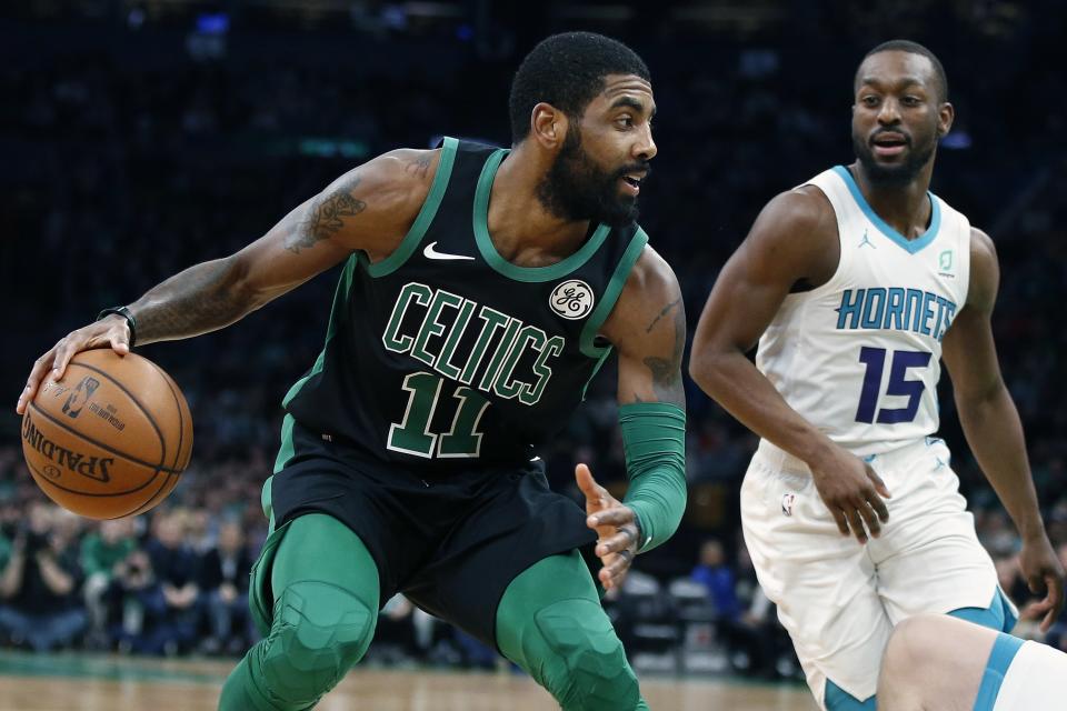 Boston Celtics' Kyrie Irving (11) drives for the basket against Charlotte Hornets' Kemba Walker (15) during the first half of an NBA basketball game in Boston, Sunday, Dec. 23, 2018. (AP Photo/Michael Dwyer)