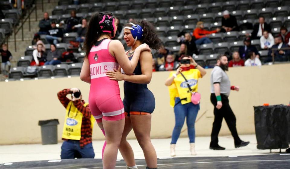 Henderson County’s Naomi Santiago, left, consoles Madison Southern’s Sierra Young after Young forfeited their 152 division finals match due to health concerns during the girls 2024 KHSAA Wrestling State Championships at the Kentucky Horse Park’s Alltech Arena on Saturday.